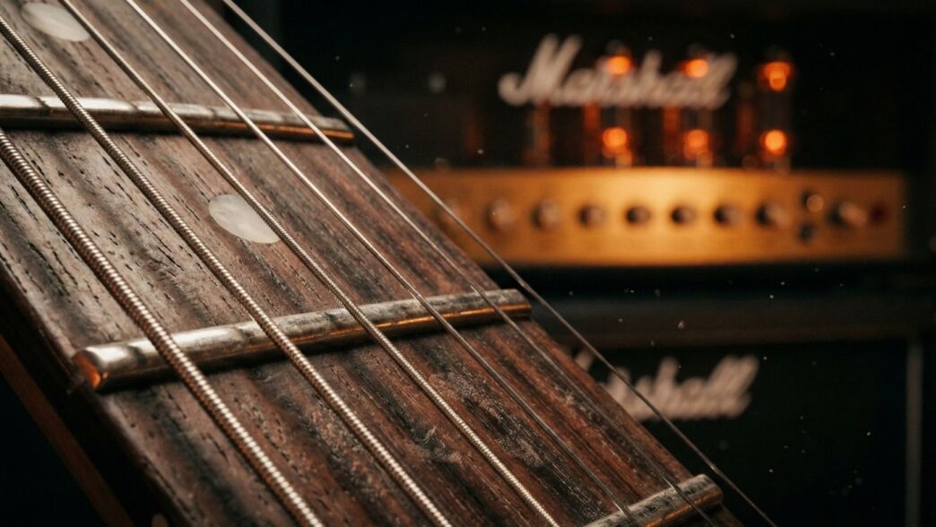 Bir elektro gitar perdesi, gitar çalmak, arkada lambalı bir marshall amfi