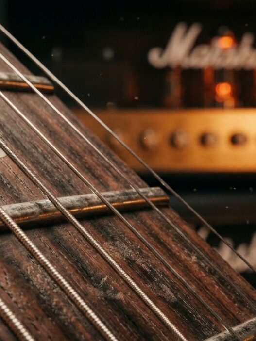 Bir elektro gitar perdesi, gitar çalmak, arkada lambalı bir marshall amfi